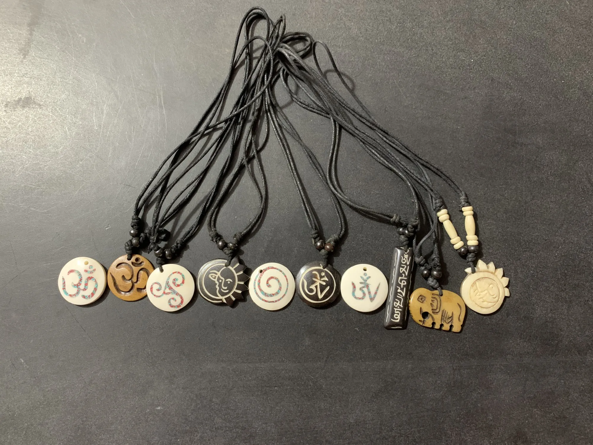 Anhänger aus Büffelknochen an Lederschnur, 10 verschiedene Motive